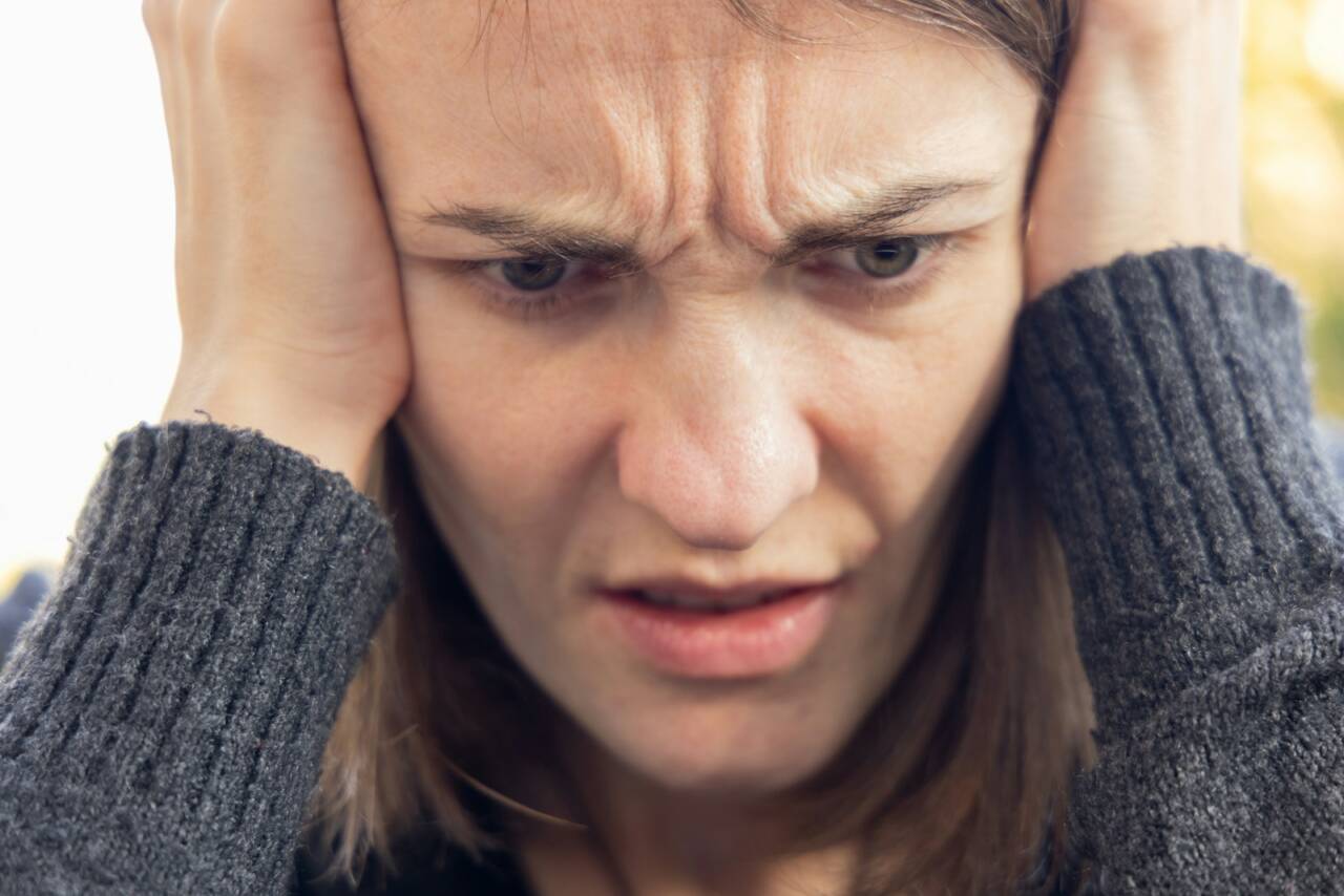 a man holding his head with both hands