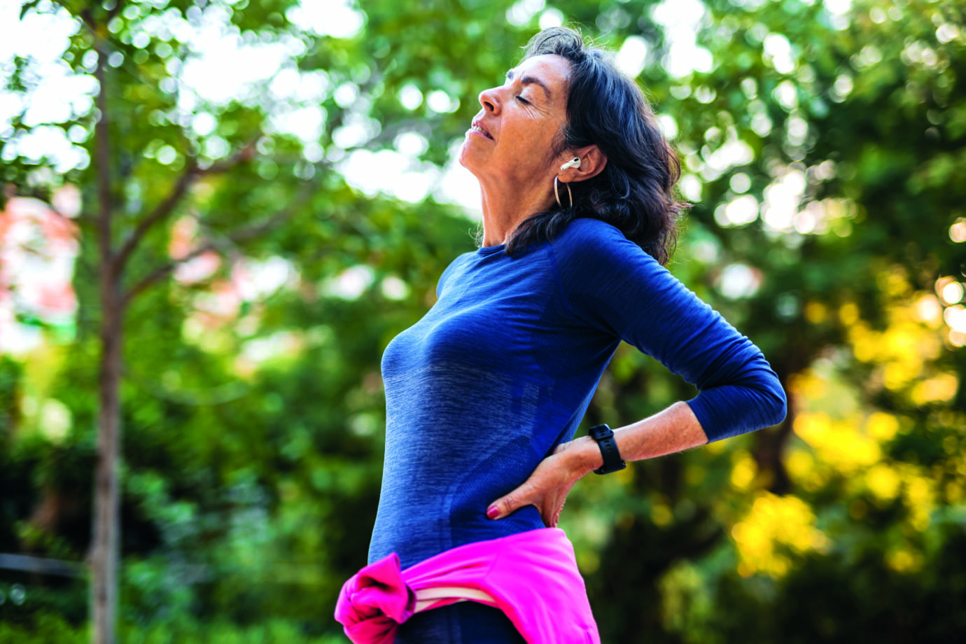 senior woman stretching her back before jogging in a public park in barcelona in spain