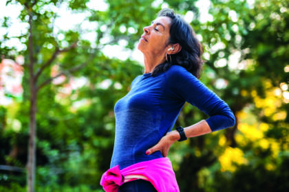 senior woman stretching her back before jogging in a public park in barcelona in spain