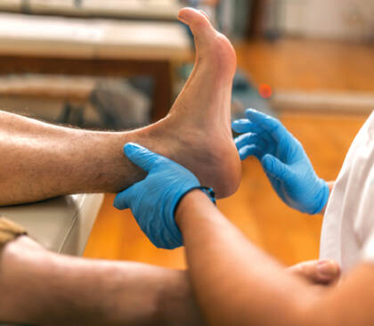 physiotherapist examining patient s ankle and foot